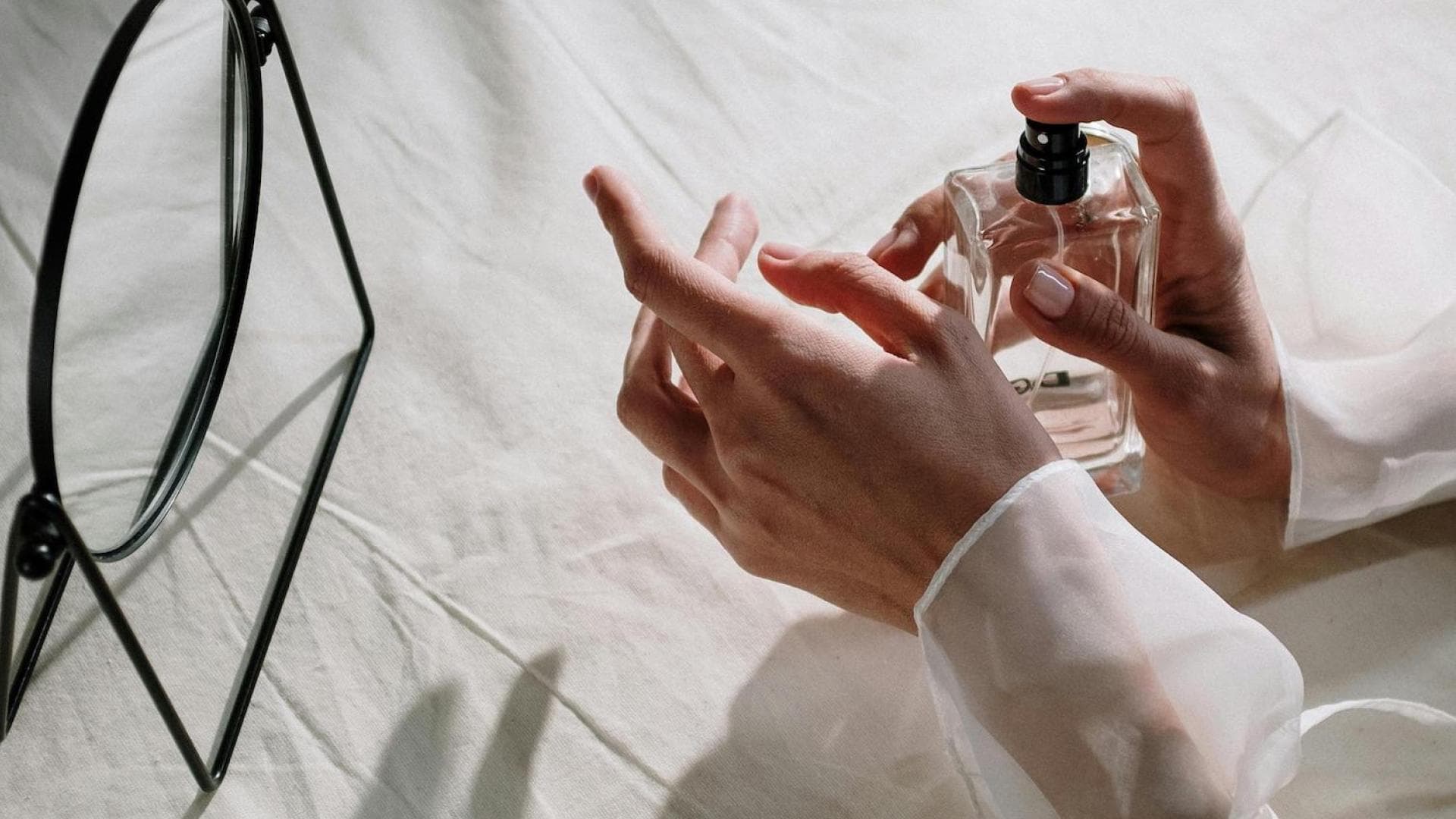 Frau trägt Parfum auf Handgelenk auf