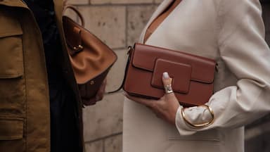 zwei Frauen mit braunen Handtaschen
