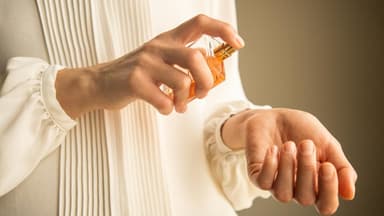 Frau trägt Parfum auf