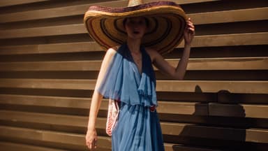 Frau mit blauem Kleid und Strandhut