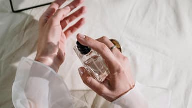 Frau sprüht Parfum auf