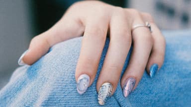 Eine Hand mit einer kreativen blauen Maniküre