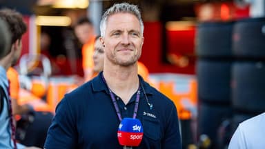 Ralf Schumacher lächelt mit Mikrofon von der Hand