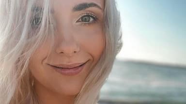 Anna Heiser mit blonden Haaren lächelt am Meer