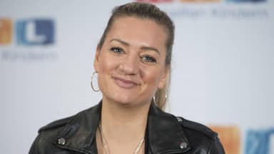 Juliette Schoppmann vor RTL-Fotowand lächelt