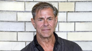 Sven Martinek steht vor einer Wand