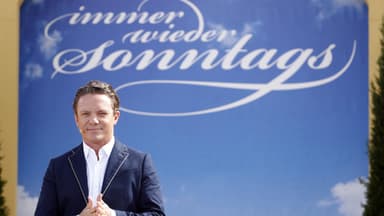 Stefan Mross mit Immer wieder sonntags Logo im Hintergrund