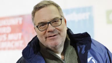 Moderator Elton lächelt leicht