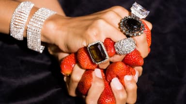 Frau mit großen Ringen hält Erdbeeren