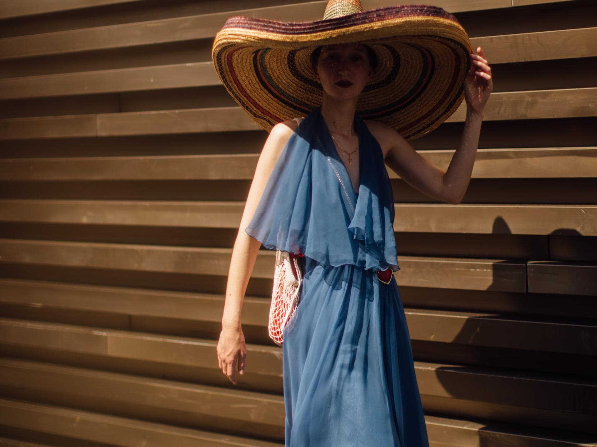 Frau mit blauem Kleid und Strandhut