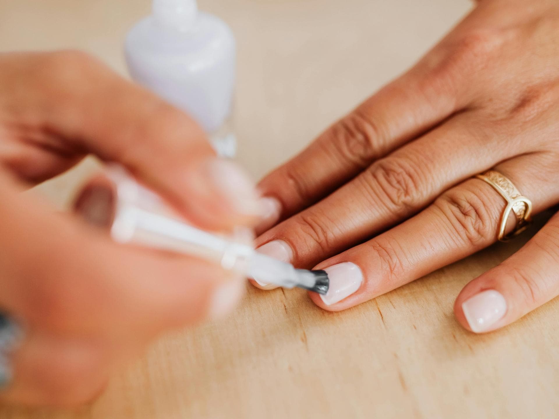 Frau trägt weißen Nagellack auf