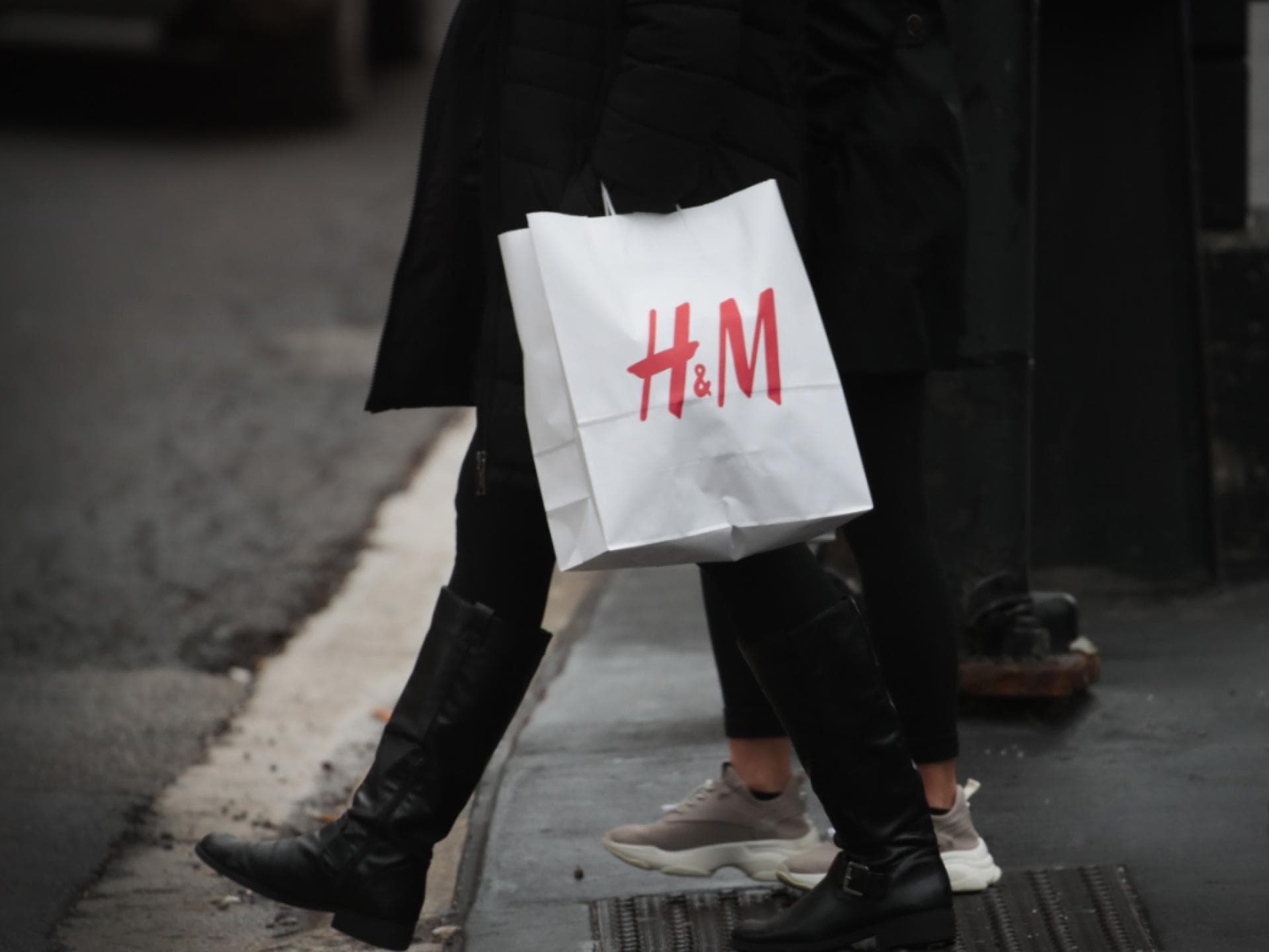 Pailletten-Bluse für Weihnachten Frau mit H&M Tüte auf Straße
