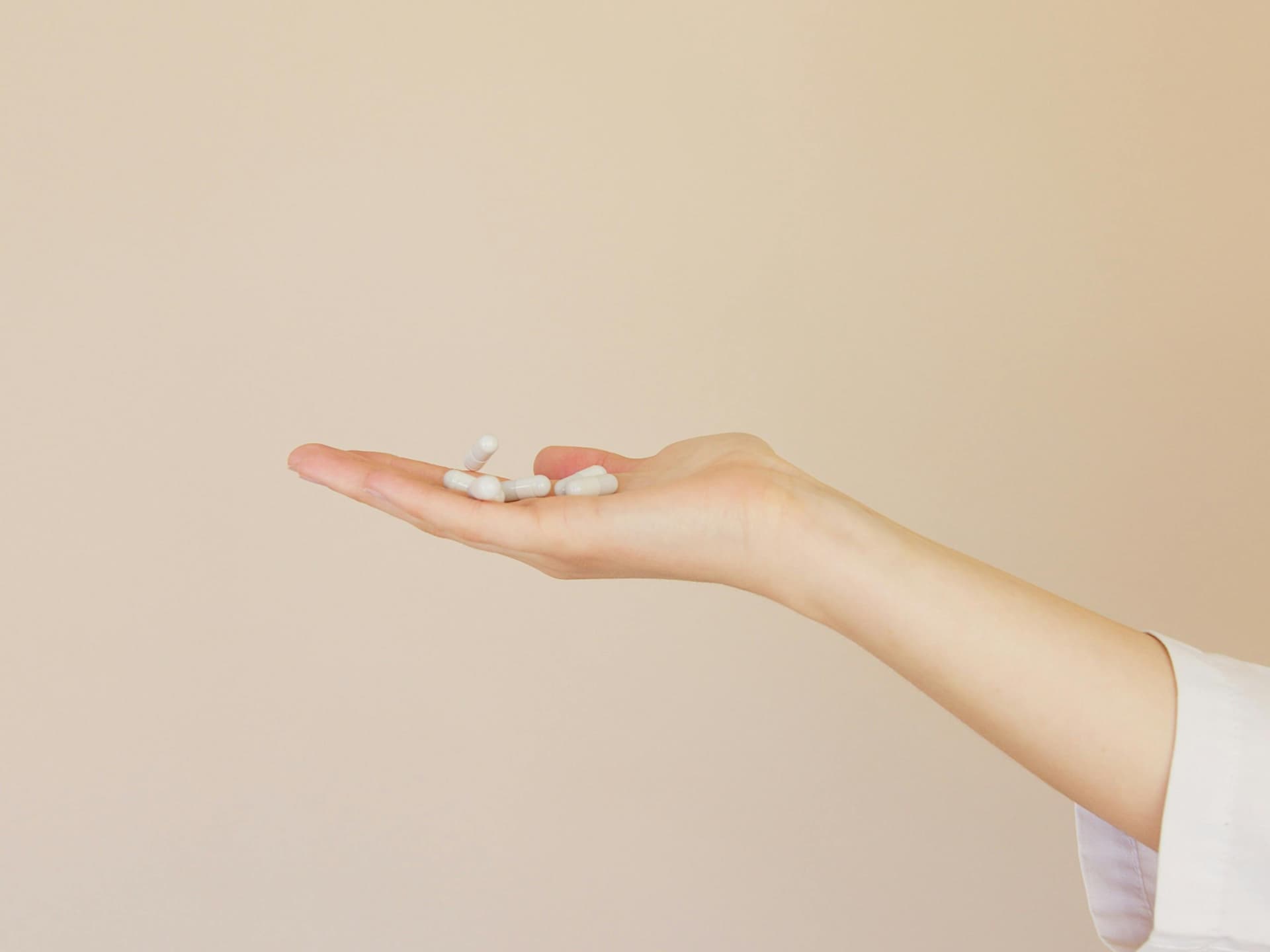 Sind Anti-Aging-Medikamente effektiv oder ein gefährlicher Trend? Frau hält Tabletten in der Hand.