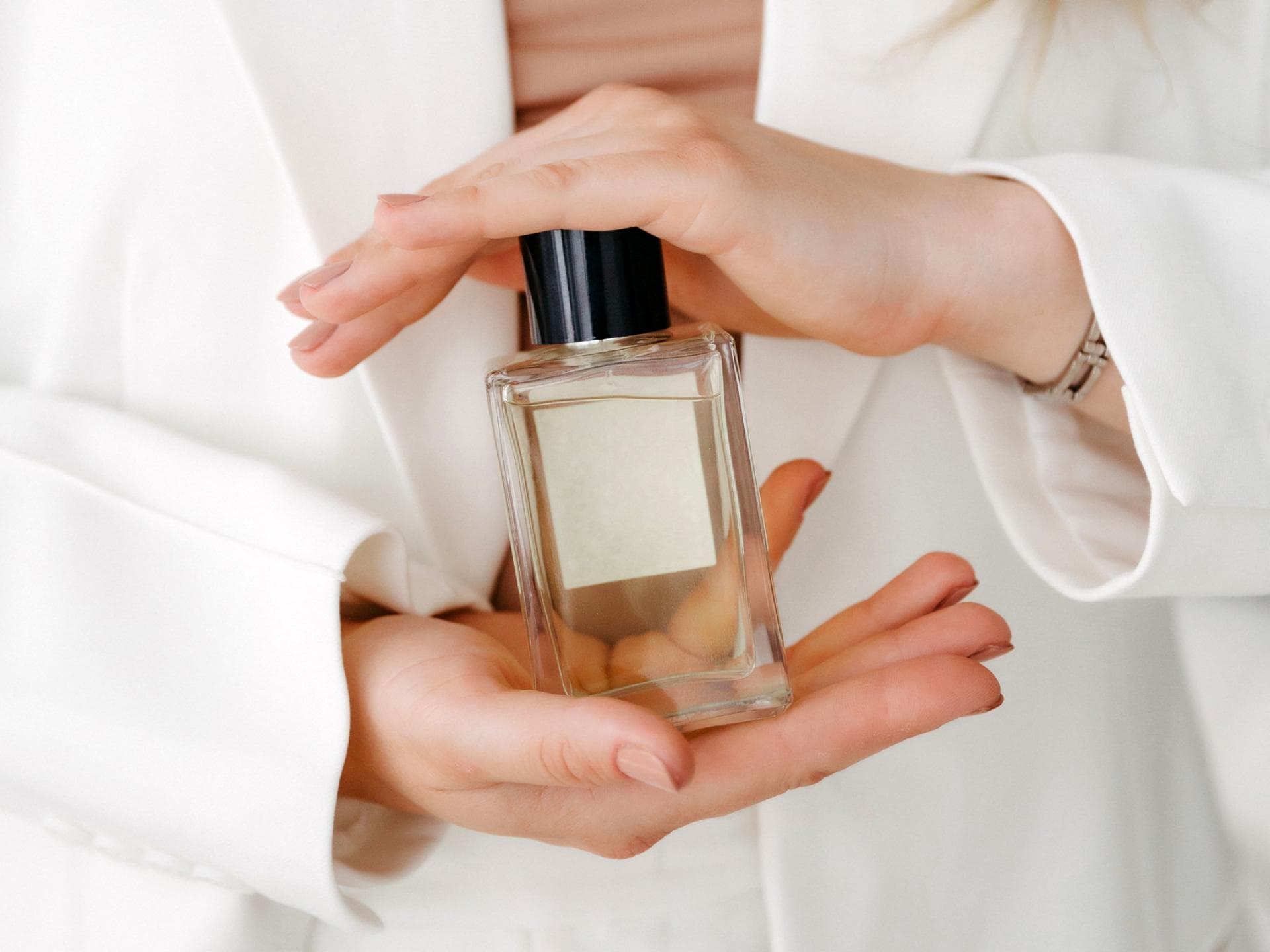 Ein Parfum sollte nicht nur gut riechen, sondern auch lange halten. Frau hält einen Parfum-Flakon zwischen den Händen.