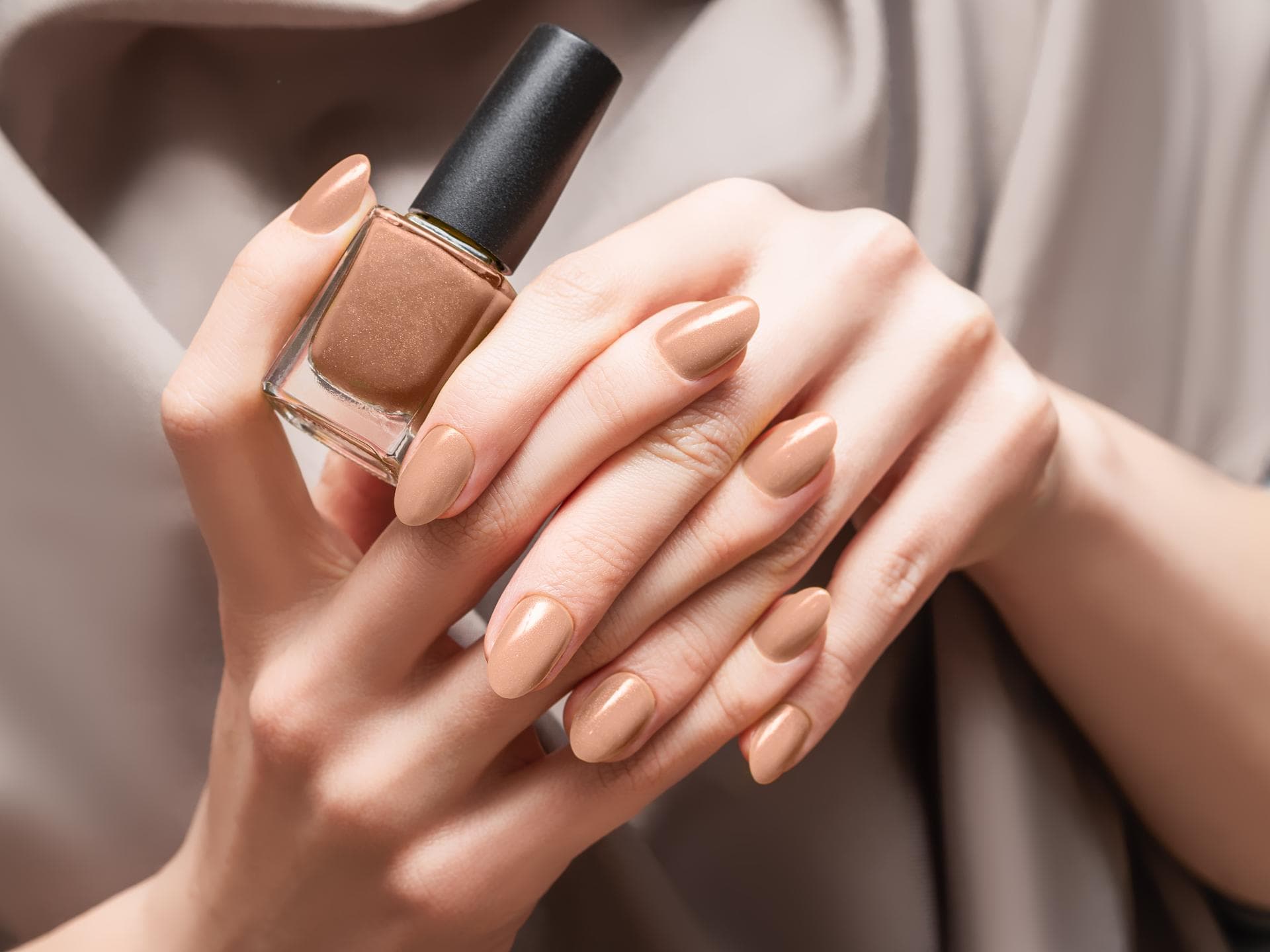 Person hält braunen Nagellack
