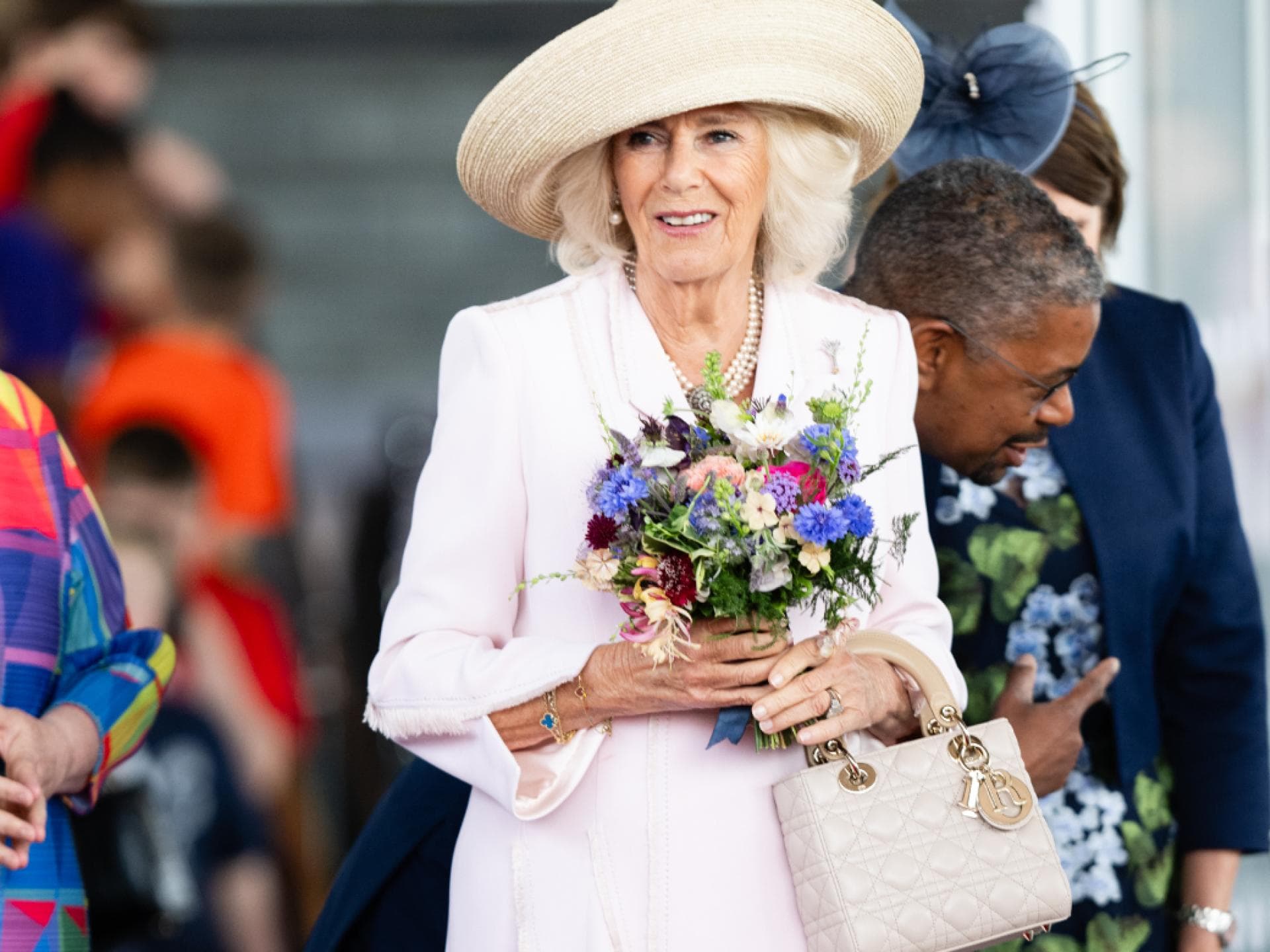 Königin Camilla mit Blumen und einer Lady Dior Bag