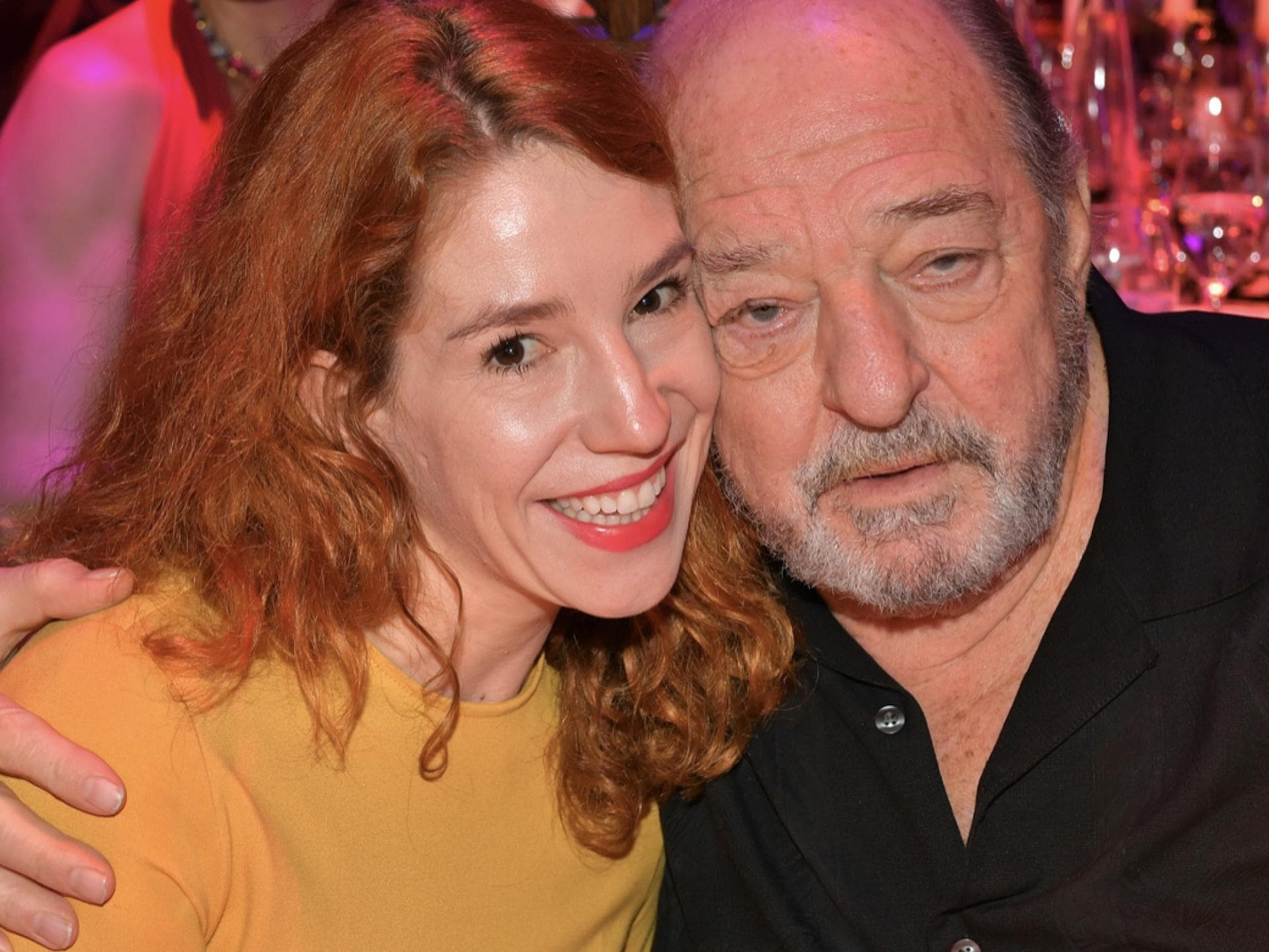 Raplh Siegel und Ehefrau Laura Kiefer sitzen nebeneinander, er hat seinen Arm um sie gelegt