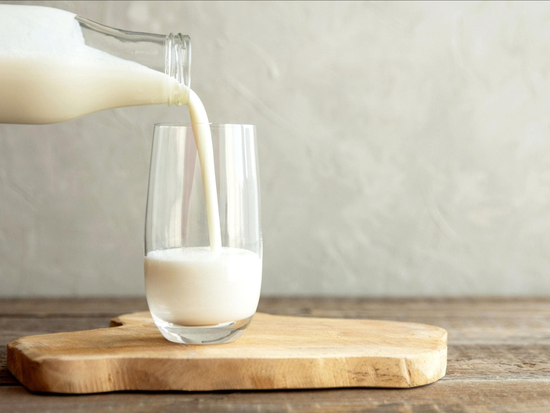 Glas Milch wird eingeschenkt Glas Milch wird eingeschenkt