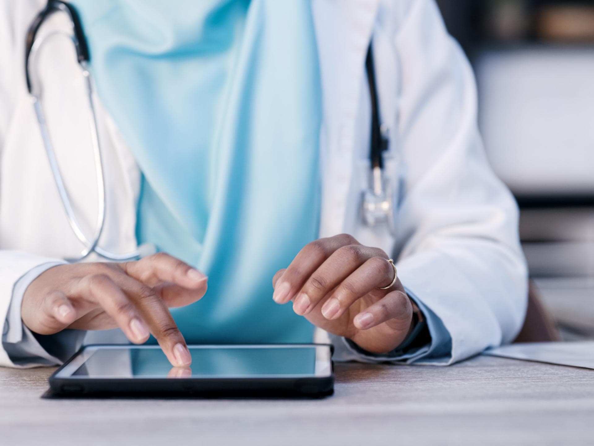 Ärztin nutzt Tablet zur Patientendatenübertragung