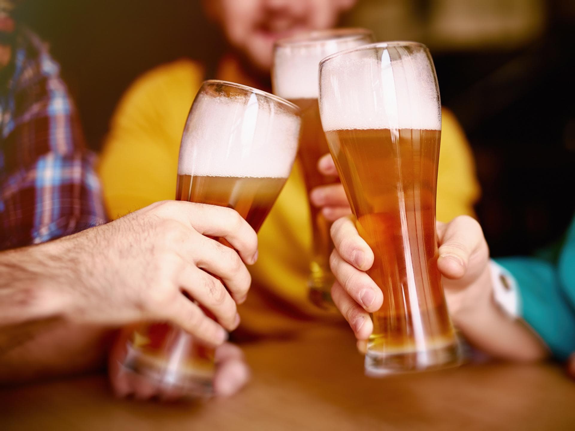 Personen stoßen mit alkoholfreiem Bier an Personen stoßen mit alkoholfreiem Bier an