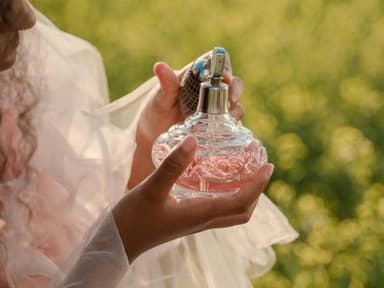 Frau mit Parfum in der Hand