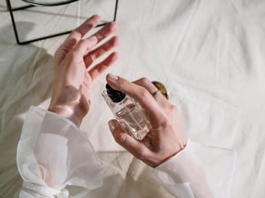 Frau sprüht Parfum auf
