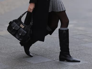 Frau trägt Stiefel und Dior-Tasche