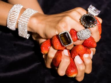 Frau mit großen Ringen hält Erdbeeren