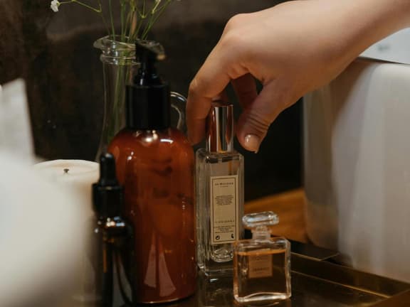Frau greift zu Parfum