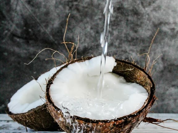 Reife Kokosnuss mit Fruchtfleisch und Wasser